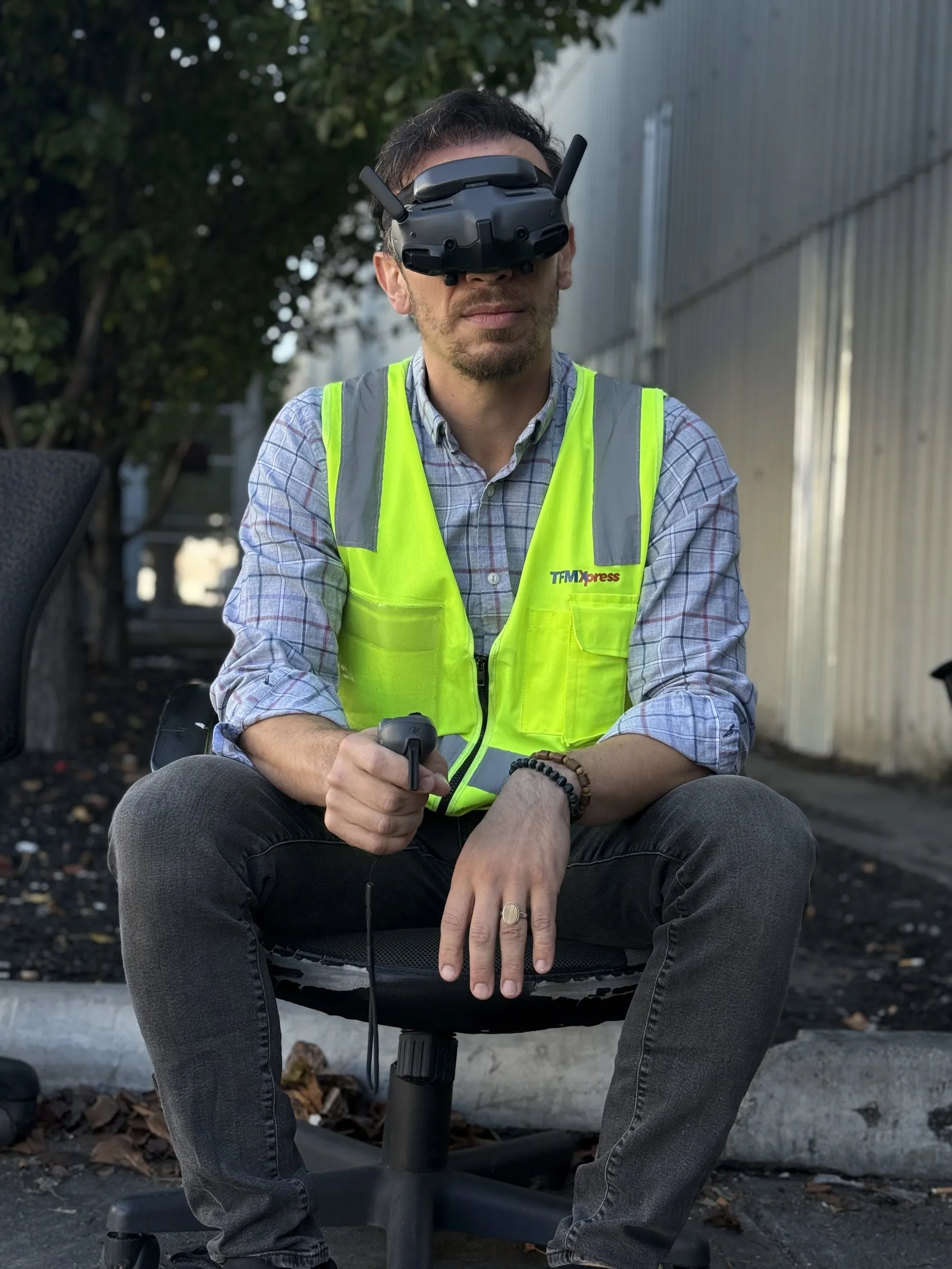 Drone pilot wearing FPV goggles at a depot