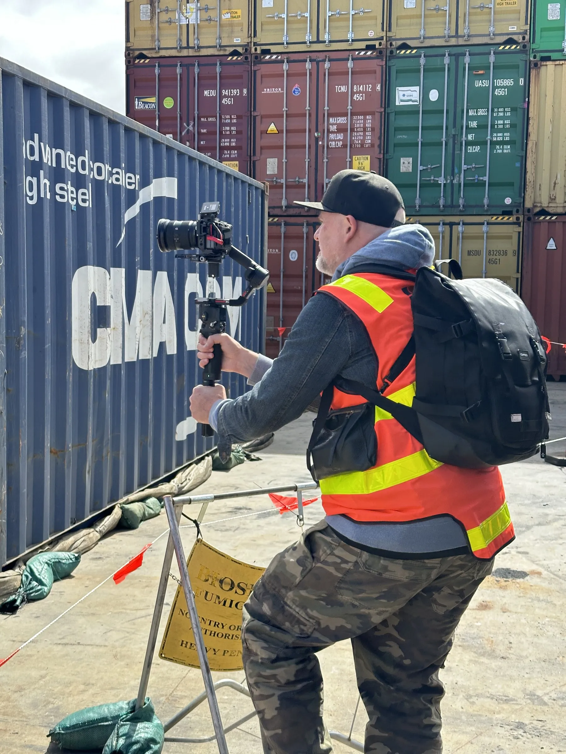 Videographer with a gimbal camera at a container yard