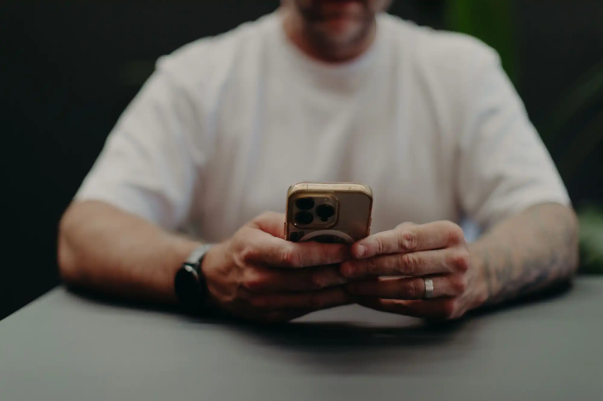 Pete Lynagh at a table scrolling on his phone, the screen where paid ads reach drivers and buyers